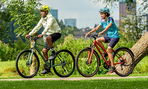 Cyclists ride cross bikes along a park.