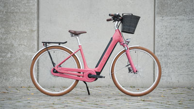 A pink Cube Ella Hybrid e-bike is on display.