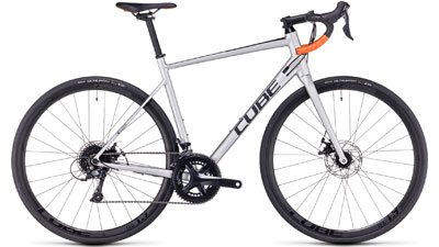 Cube Attain Pro road bike in silver with orange drop bar grips.