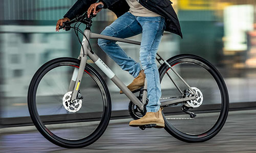 A cyclist rides his exercise bike through the city; the cyclist is only partially visible.