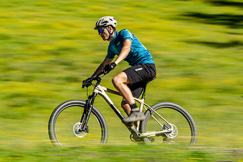 Cyclist wearing a blue T-shirt and helmet on a Cube Reaction mountain bike hardtail.