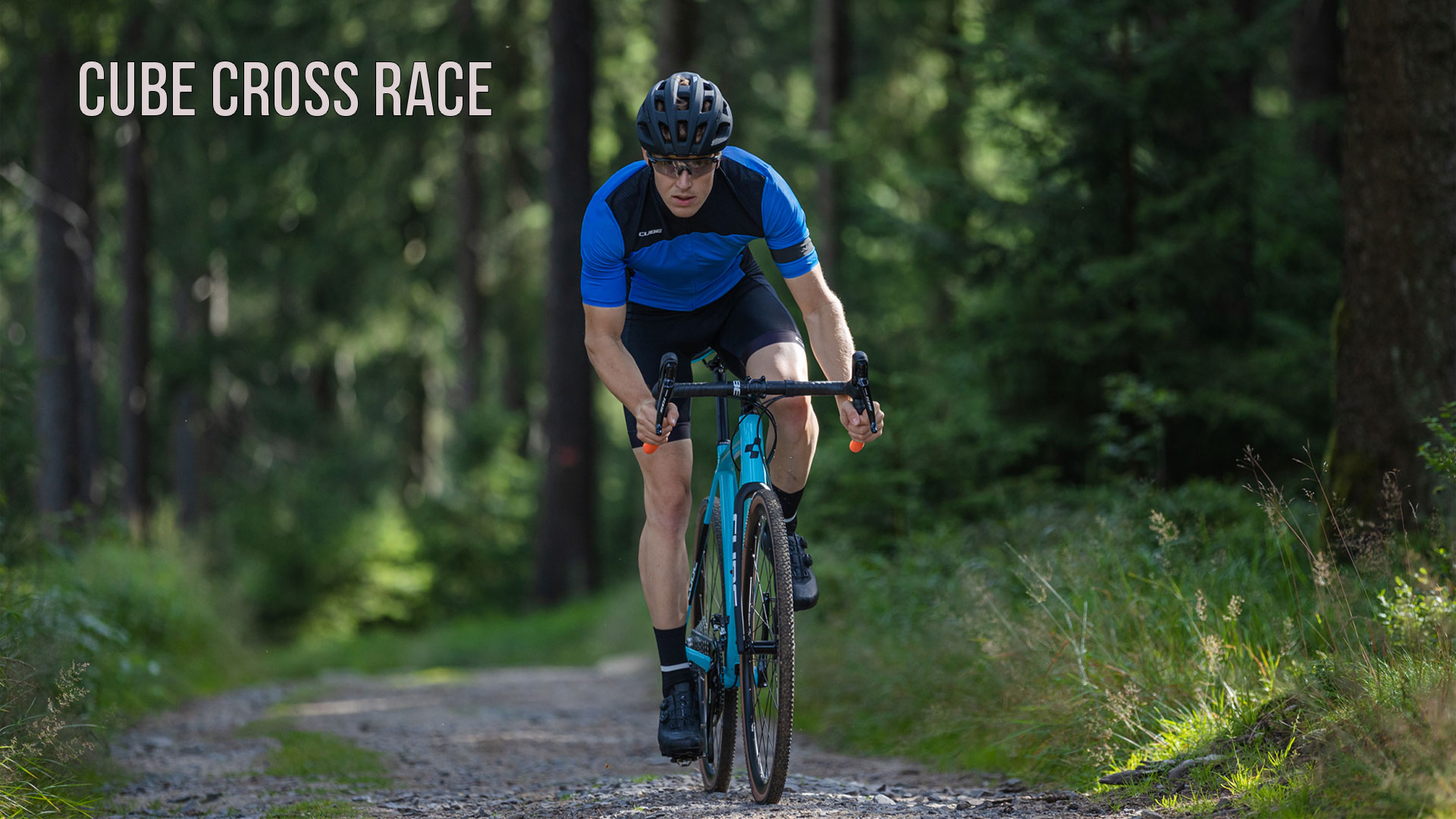 A man rides a Cube Cross Race bike through the forest.